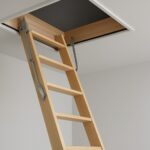 A wooden loft ladder extending through a ceiling hatch in a minimalist room